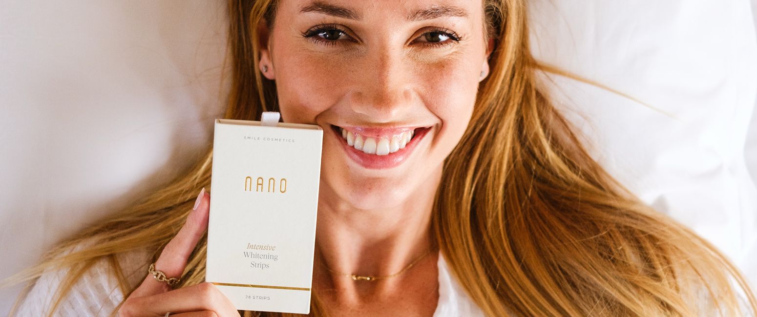 Smiling woman holding Nano Intensive Whitening Strips